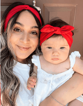 Mom and daughter are wearing matching mommy and me head wraps from By Bella Boutique.